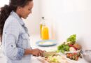 Mulher cortando vegetais frescos na cozinha durante preparo de refeição balanceada, ilustrando 3 dicas de alimentação saudável para manter hábitos nutritivos no dia a dia.