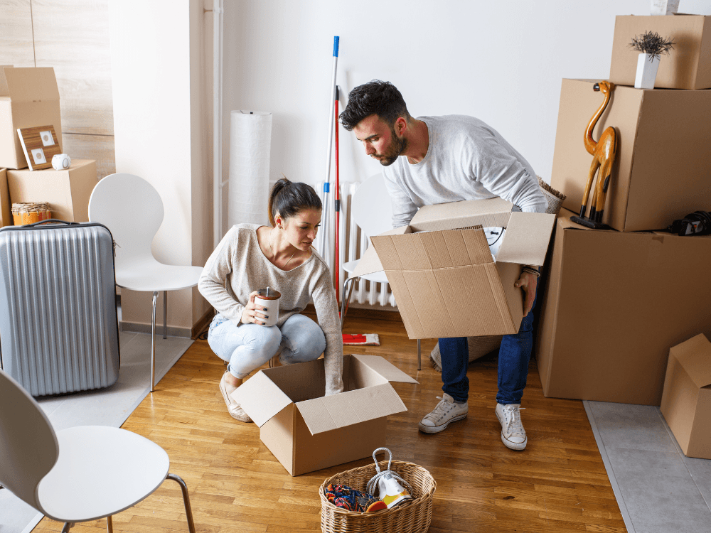 Casal empacotando caixas para mudança de apartamento
