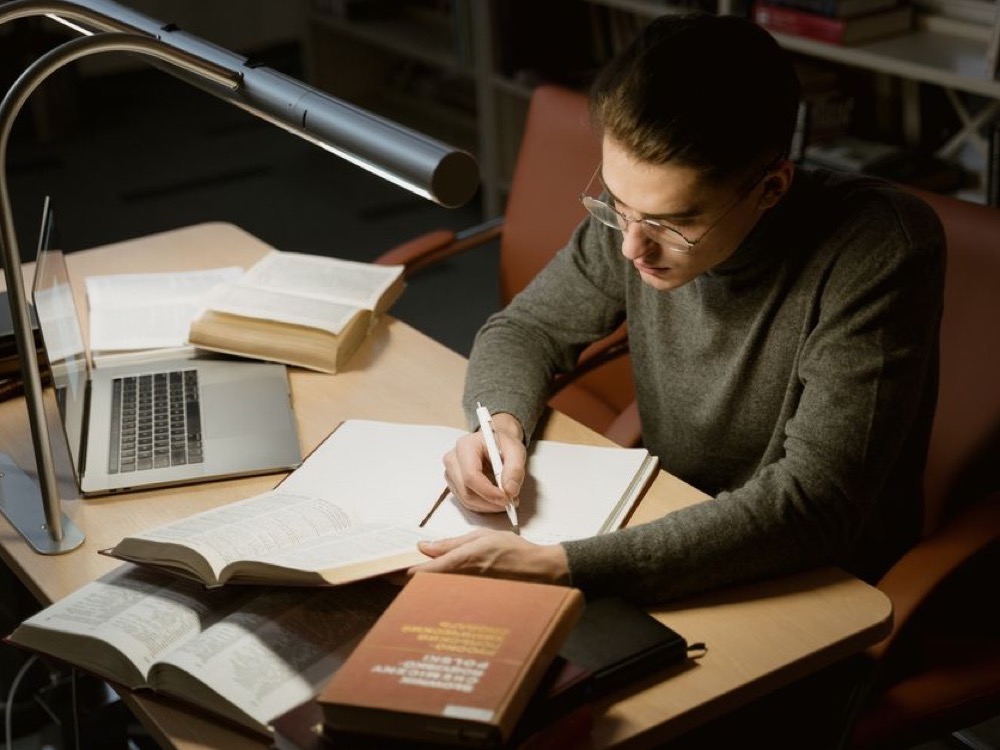 Imagem de capa de homem estudando com um caderno e laptop